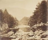 Man reading by river, photographed by Roger...