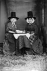 Two women in national dress drinking tea (Jones)