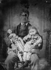 man holding a child and a doll