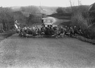 Woman herding turkeys across a road in front of...