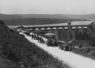 Men and women in buses and cars visiting a...