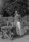 Man standing next to a garden table on which...