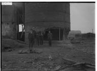 Group standing next to damaged structure, Port...