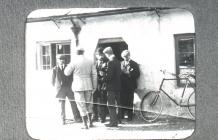 Men and bicycle outside house in Usk, 1902