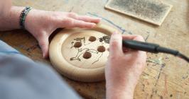 A close-up of a pyrography work in progress of...